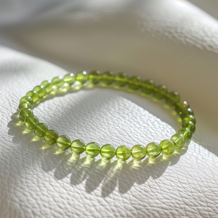 Luminous peridot jewelry is showcased in a photo of a small bead peridot bracelet in sunlight.