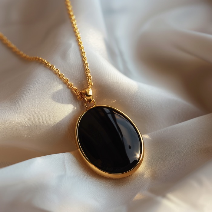 Large oval black onyx pendant plated in gold on a gold plated chain.